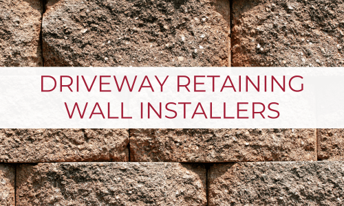 Large retaining wall with text overlaid on a white background saying “Driveway Retaining Wall Installers”.